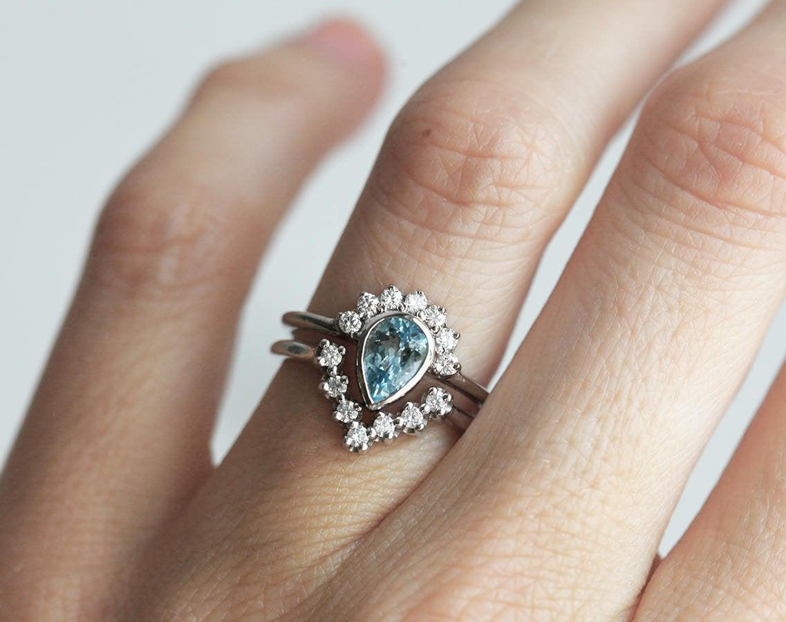 Birnenförmiger Aquamarinring mit runden weißen Diamanten, die einen Heiligenschein bilden