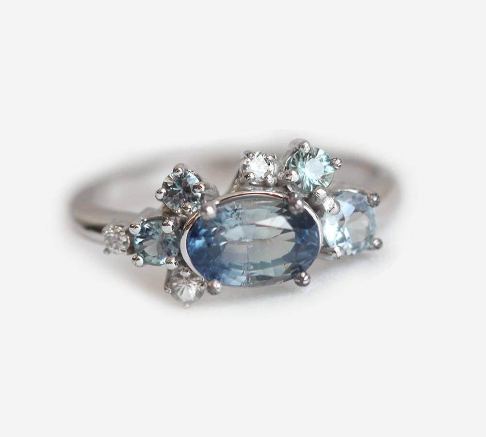 Blauer ovaler Saphirring mit Diamantcluster