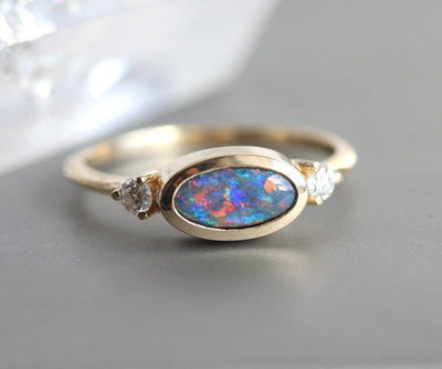 Ovaler Ring aus drei Steinen mit schwarzem Opal und zwei seitlichen weißen Diamanten