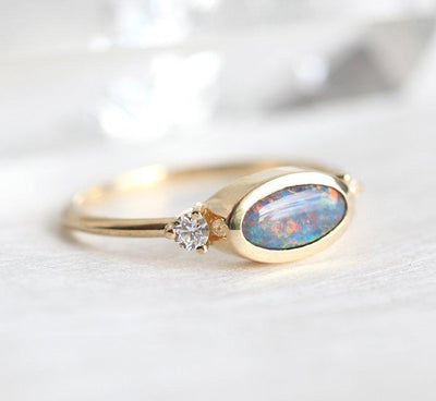 Ovaler Ring aus drei Steinen mit schwarzem Opal und zwei seitlichen weißen Diamanten