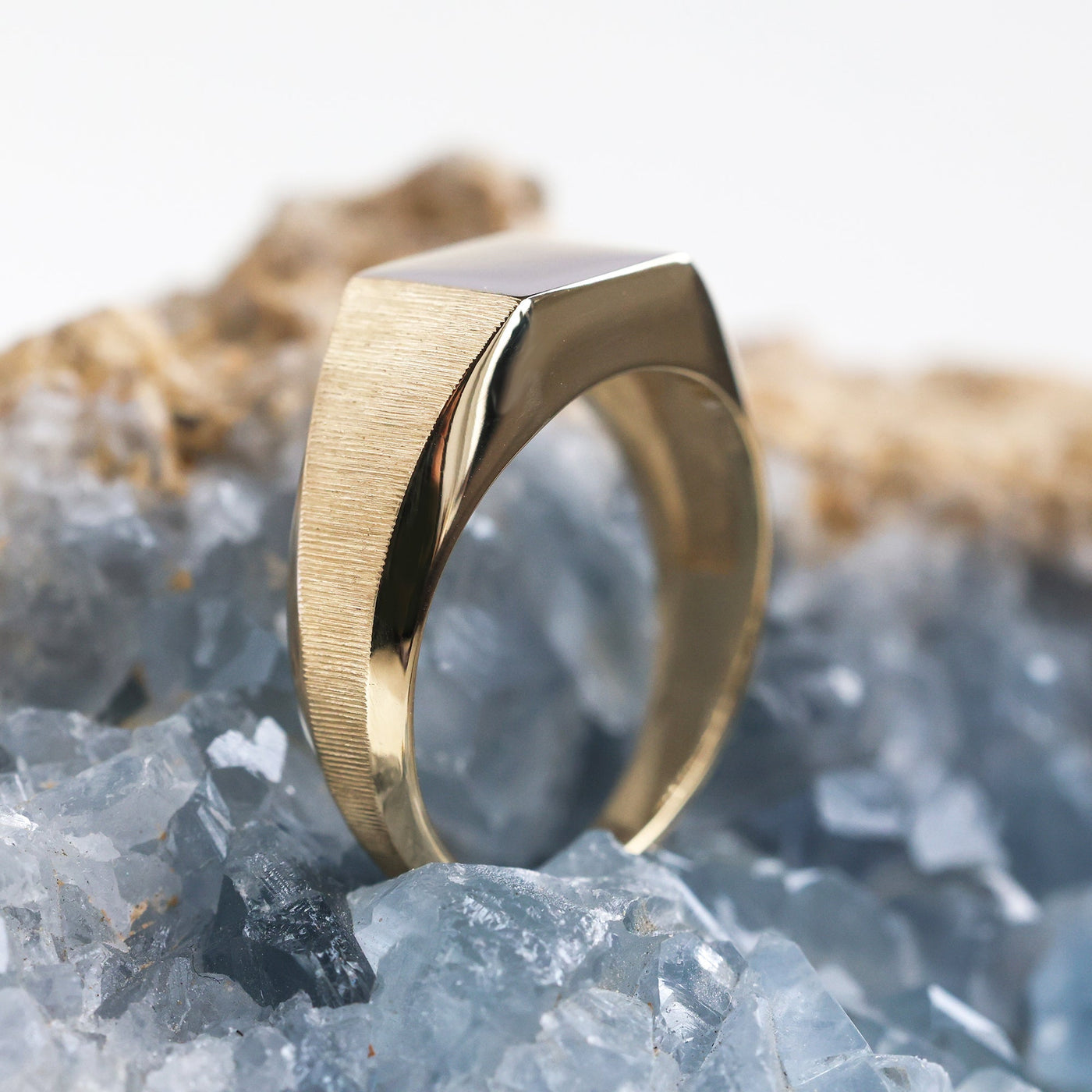 Goldsiegelring auf Felsen, Nahaufnahme. Premium-Metalloptionen: Sterlingsilber, Gold, Platin. Personalisierbar mit Edelsteinen. Detaillierte Abmessungen und Ausführungen.