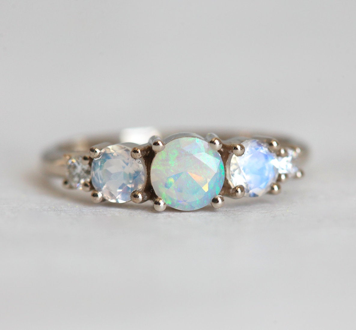 Runder Opal-Cluster-Ring mit seitlichen Mondsteinen und weißen Diamanten