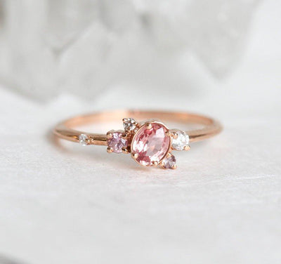 Ovaler rosa-pfirsichfarbener Saphirring mit Diamantcluster