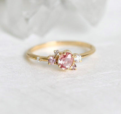 Ovaler rosa-pfirsichfarbener Saphirring mit Diamantcluster