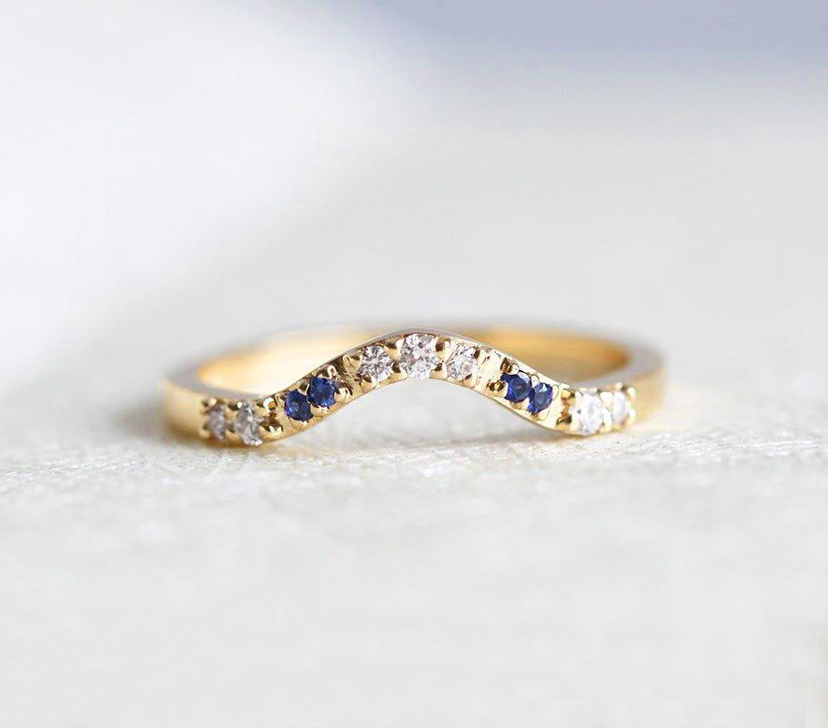 Geschwungener Ehering mit Diamanten und blauem Saphir in Pavé-Fassung