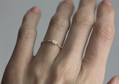 Baguette-Diamant-Solitär-Goldring mit feinem geometrischen Muster auf dem Ring