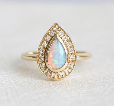 Weißer Birnen-Opal-Halo-Ring aus Gelbgold mit runden weißen Diamanten, die den Hauptedelstein umgeben