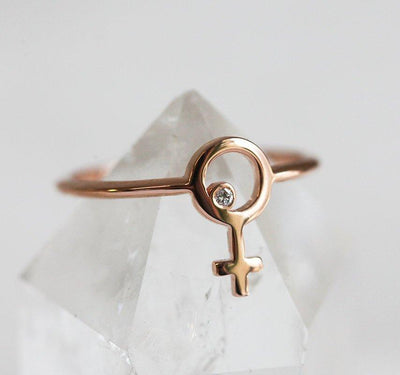 Ring aus Roségold mit einem kleinen runden Diamanten in der Mitte eines weiblichen Symbols