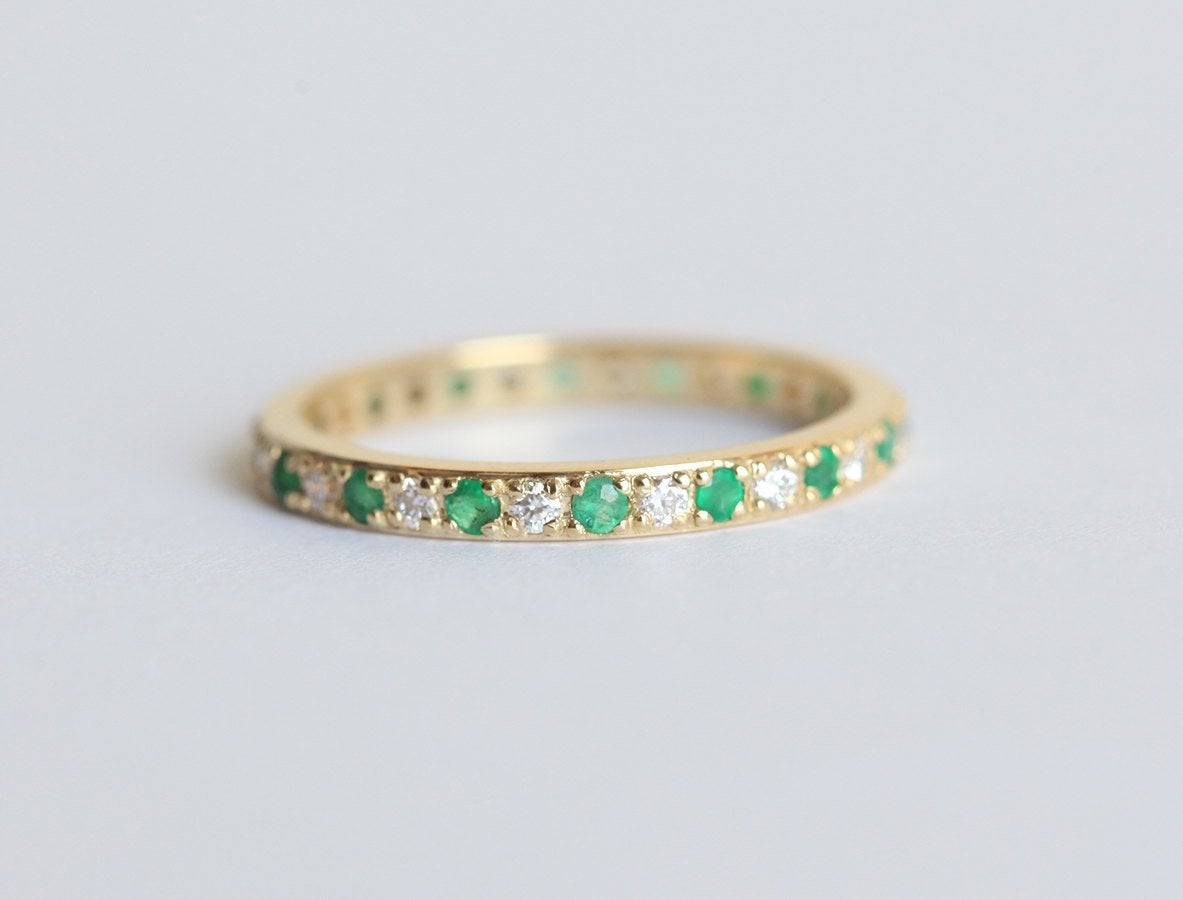 Handgefertigter Ring aus 18-karätigem Gold mit Smaragden und Diamanten im Eternity-Stil. Perfekt für besondere Anlässe.