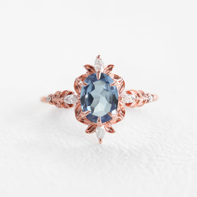 Ovaler Verlobungsring mit blauem Saphir und weißen Marquise-Diamanten, ein atemberaubendes Symbol für Eleganz.