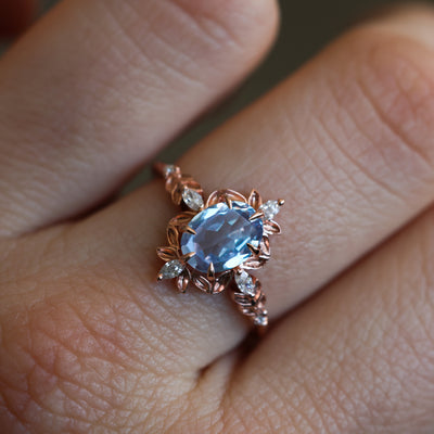 Ovaler Verlobungsring mit blauem Saphir und weißen Marquise-Diamanten, ein atemberaubendes Symbol der Liebe.