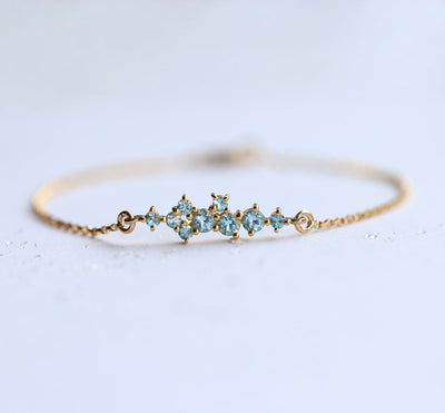 Goldkettenarmband mit rundem Blautopas-Cluster