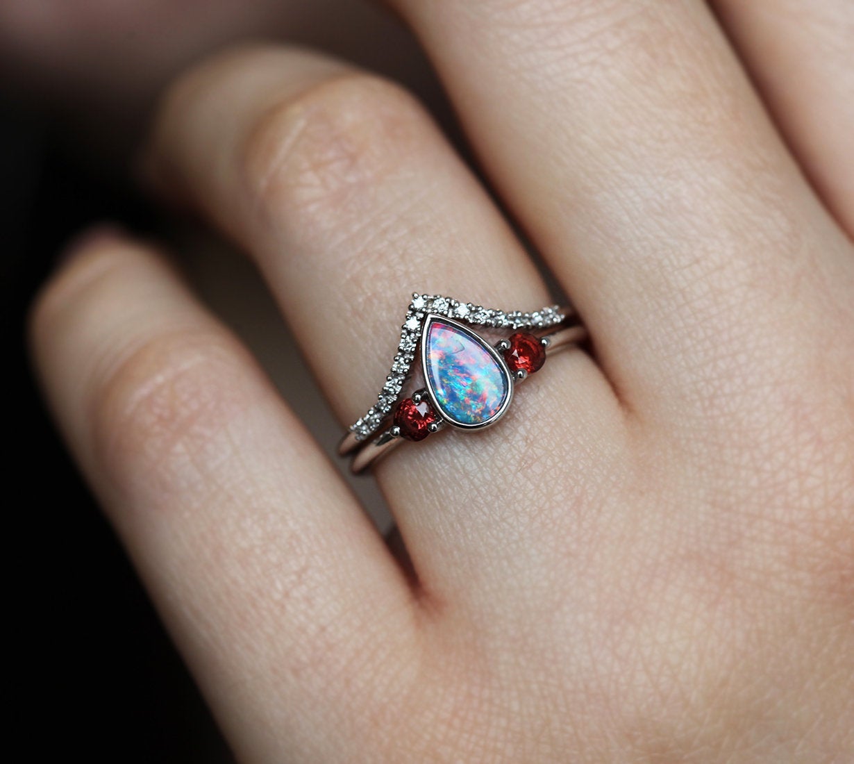 Drei-Stein-Ring mit schwarzem Birnen-Australier-Opal mit akzentuierten roten runden Granat-Edelsteinen und Diamant-Kronenband