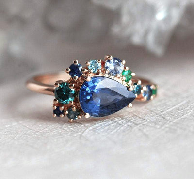 Birnenförmiger blauer Saphir-Clusterring mit Diamant-, Topas- und Smaragd-Seitensteinen