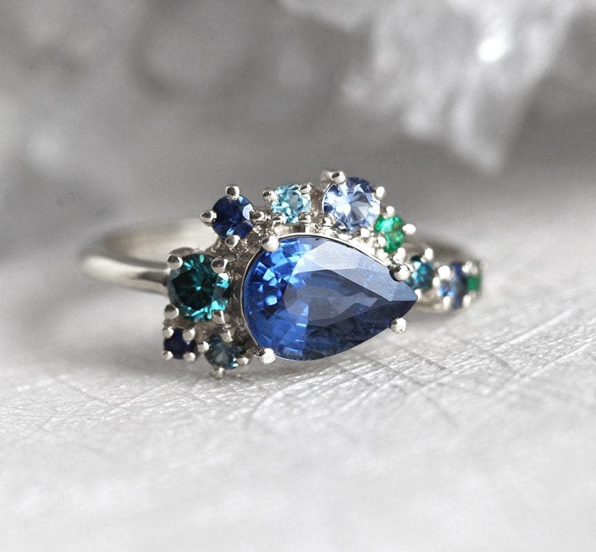 Birnenförmiger blauer Saphir-Clusterring mit Diamant-, Topas- und Smaragd-Seitensteinen