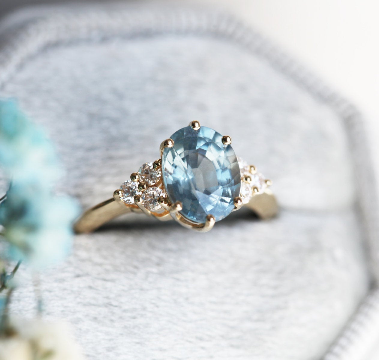 Ovaler blauer Saphirring mit Diamantcluster