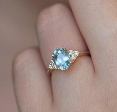 Ovaler blauer Saphirring mit Diamantcluster