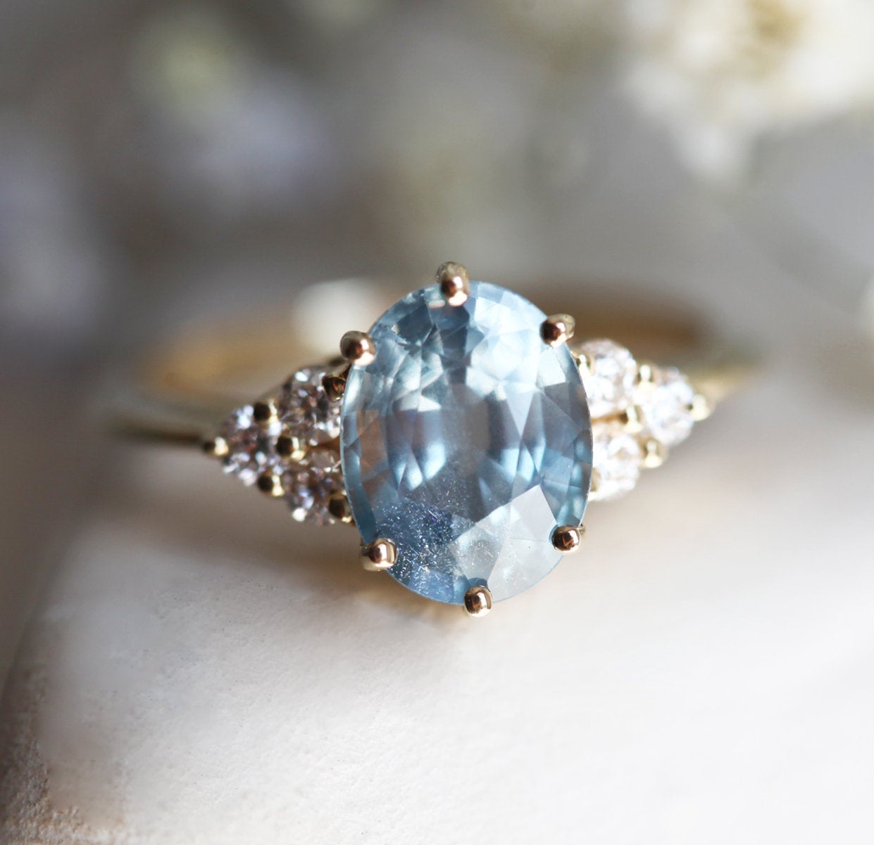 Ovaler blauer Saphirring mit Diamantcluster