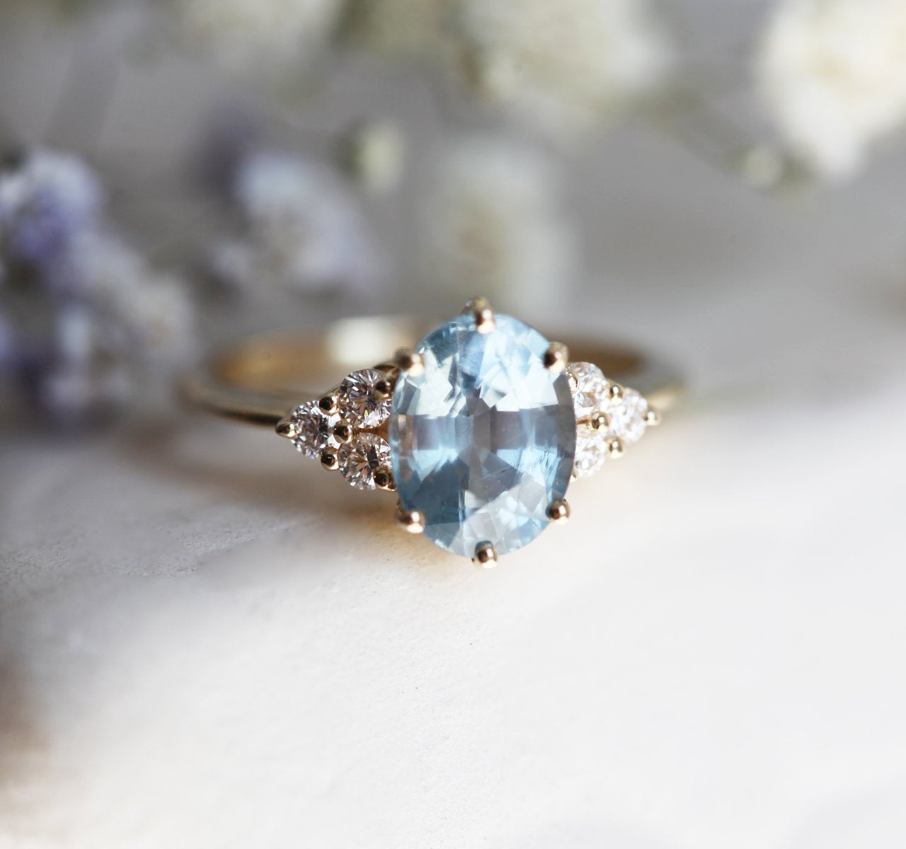 Ovaler blauer Saphirring mit Diamantcluster