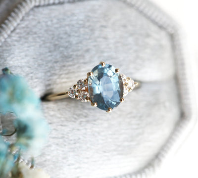 Ovaler blauer Saphirring mit Diamantcluster