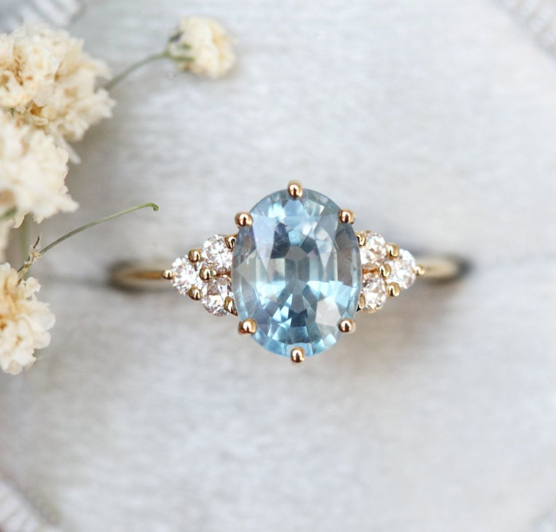 Ovaler blauer Saphirring mit Diamantcluster