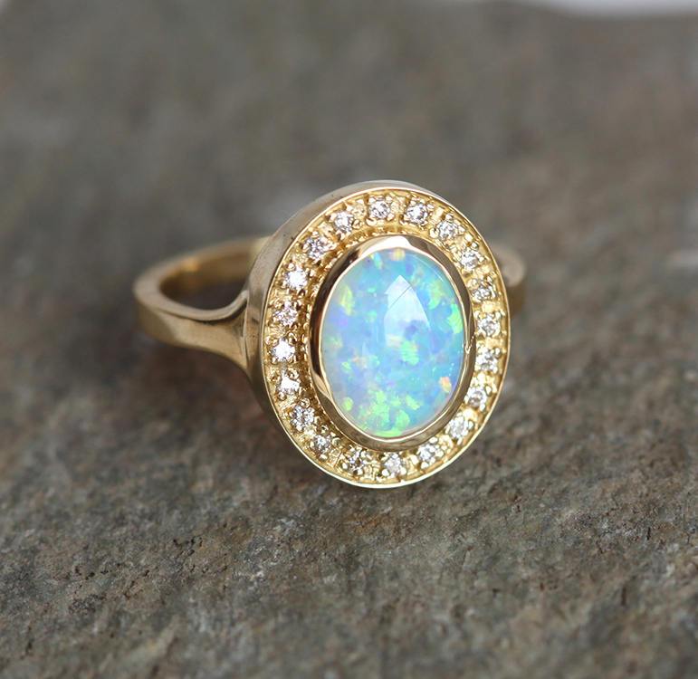 Ovaler Opal-Halo-Ring aus Gelbgold mit seitlichen weißen runden Diamanten