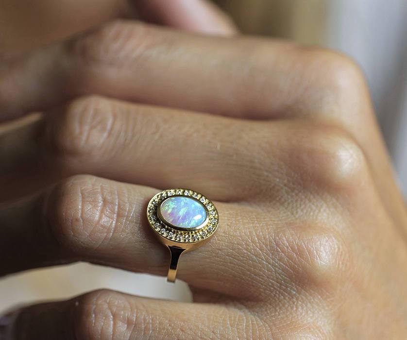 Ovaler Opal-Halo-Ring aus Gelbgold mit seitlichen weißen runden Diamanten