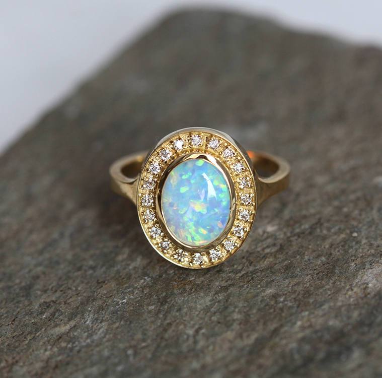 Ovaler Opal-Halo-Ring aus Gelbgold mit seitlichen weißen runden Diamanten