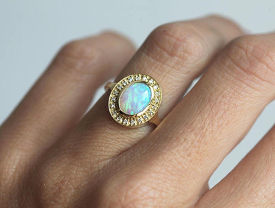 Ovaler Opal-Halo-Ring aus Gelbgold mit seitlichen weißen runden Diamanten