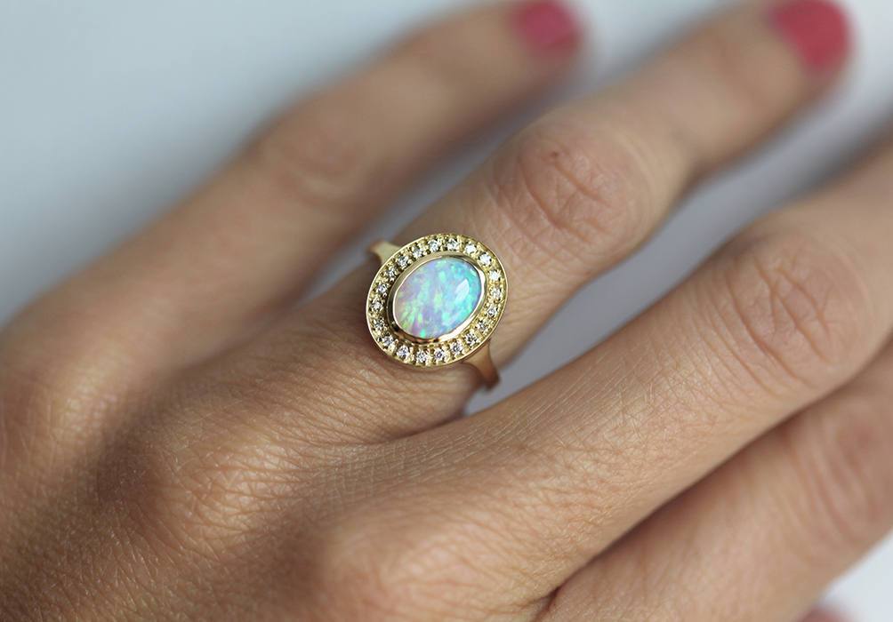 Ovaler Opal-Halo-Ring aus Gelbgold mit seitlichen weißen runden Diamanten