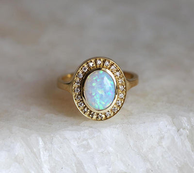 Ovaler Opal-Halo-Ring aus Gelbgold mit seitlichen weißen runden Diamanten