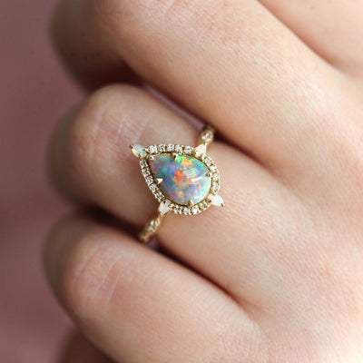 Birnen-Opal-Halo-Ring mit seitlichen runden weißen Diamanten und Birnen-Opalen