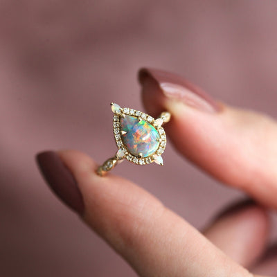 Birnen-Opal-Halo-Ring mit seitlichen runden weißen Diamanten und Birnen-Opalen