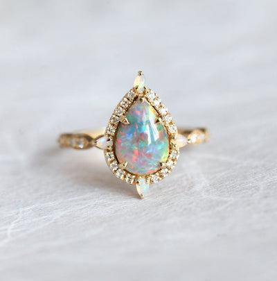 Birnen-Opal-Halo-Ring mit seitlichen runden weißen Diamanten und Birnen-Opalen