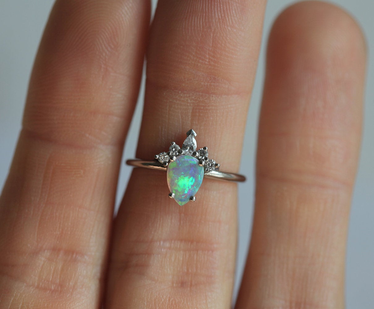 Weißer Birnen-Opal-Ring mit seitlich runden und birnenförmigen Diamanten