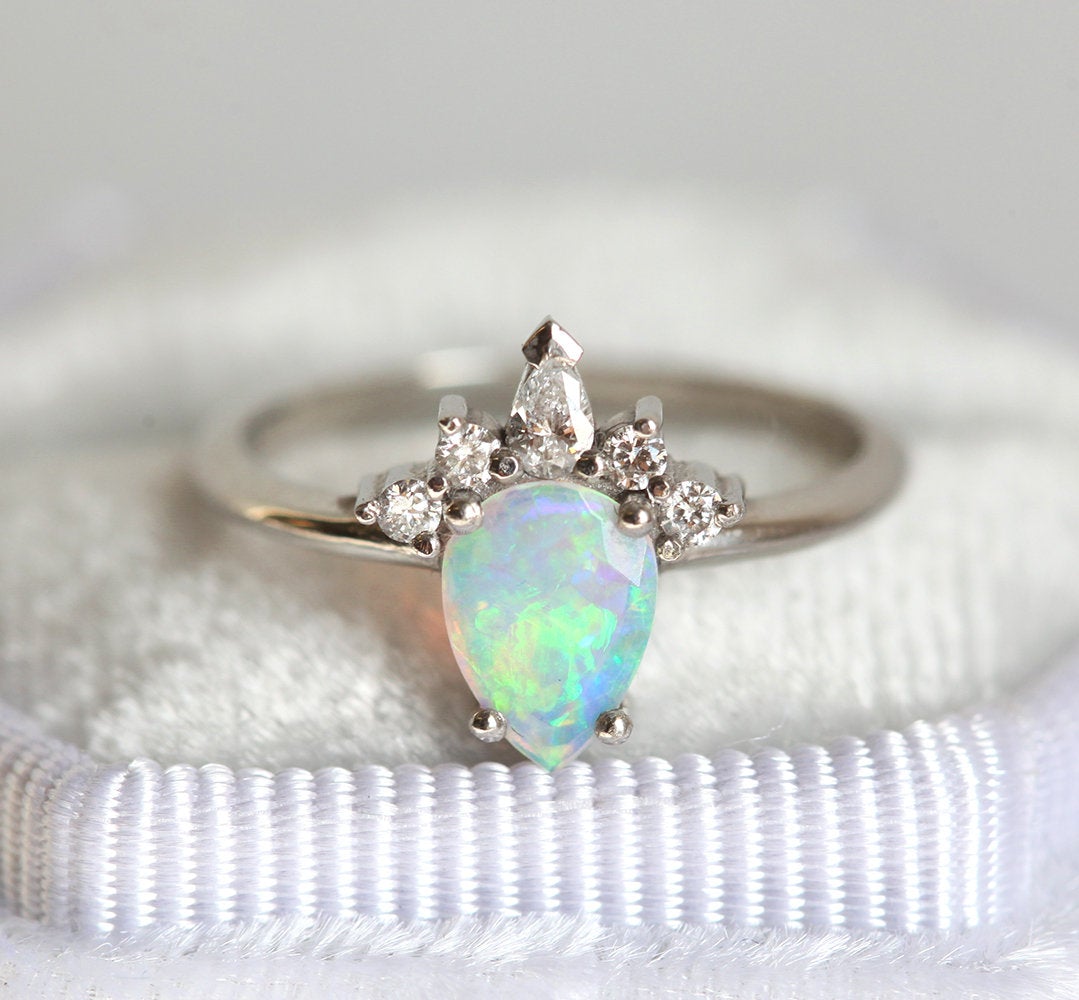 Weißer Birnen-Opal-Ring mit seitlich runden und birnenförmigen Diamanten