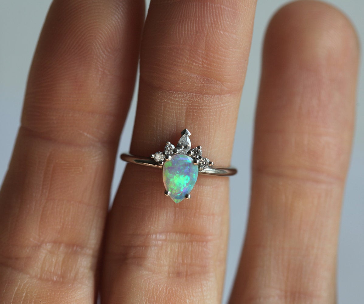 Weißer Birnen-Opal-Ring mit seitlich runden und birnenförmigen Diamanten