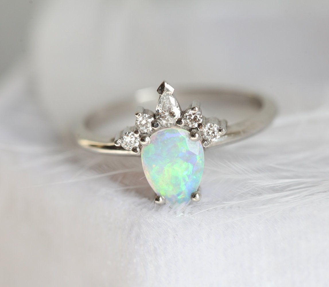 Weißer Birnen-Opal-Ring mit seitlich runden und birnenförmigen Diamanten