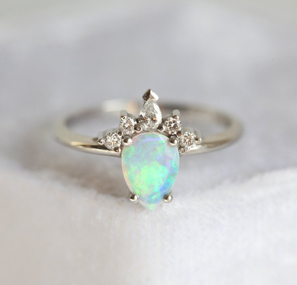 Weißer Birnen-Opal-Ring mit seitlich runden und birnenförmigen Diamanten