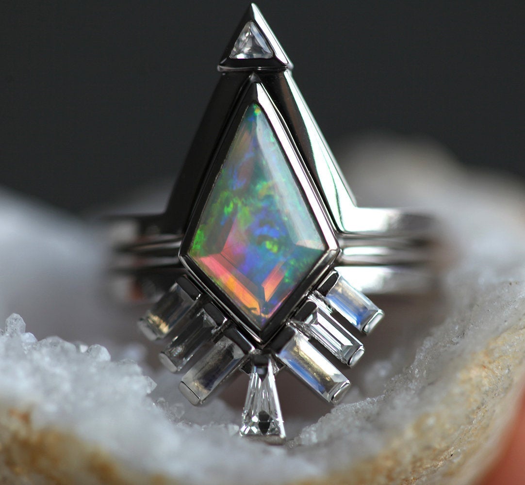 Weißer Kite-Opal-Ring, besetzt mit Baguette-Mondsteinen und konischen Baguette-Diamanten