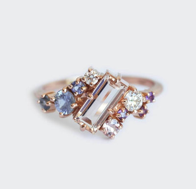 Rosafarbener Morganit-Verlobungsring im Baguetteschliff, besetzt mit Diamant-, Saphir- und Amethyst-Edelsteinen in asymmetrischer Wellenform