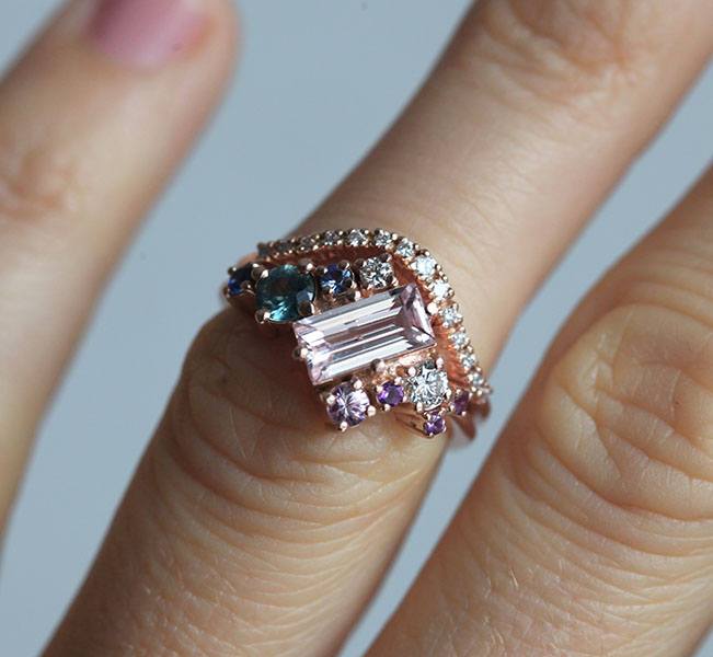 Rosafarbener Morganit-Verlobungsring im Baguetteschliff, besetzt mit Diamant-, Saphir- und Amethyst-Edelsteinen in asymmetrischer Wellenform