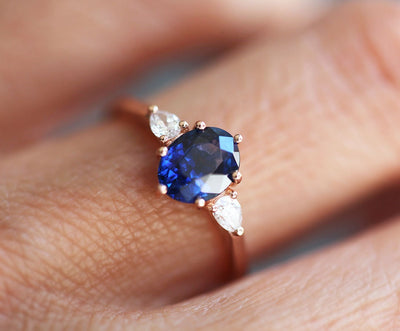 Ovaler blauer Saphirring mit weißen Diamanten an der Seite