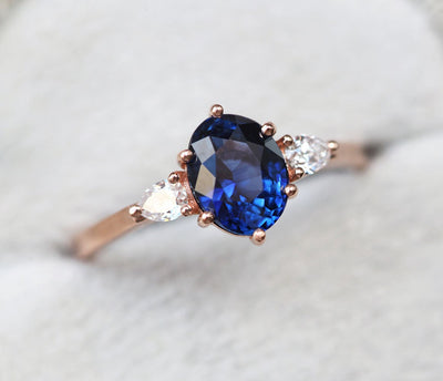 Ovaler blauer Saphirring mit weißen Diamanten an der Seite