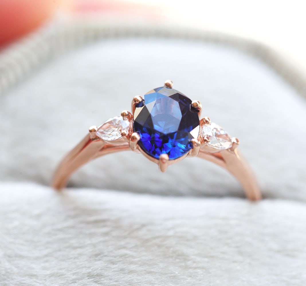 Ovaler blauer Saphirring mit weißen Diamanten an der Seite