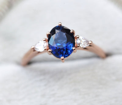 Ovaler blauer Saphirring mit weißen Diamanten an der Seite