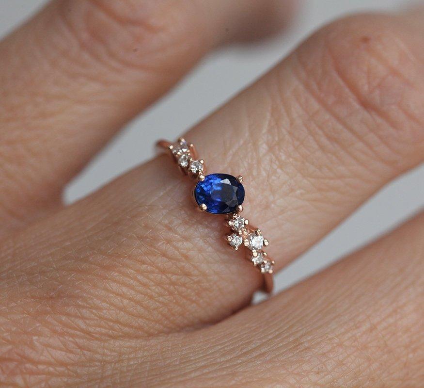 Ovaler blauer Saphir-Clusterring mit Diamanten