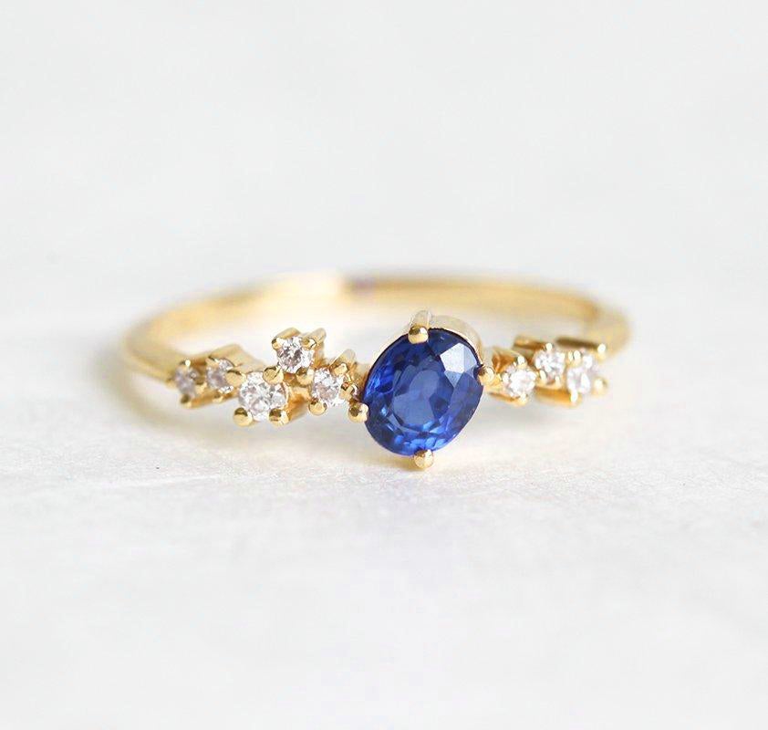 Ovaler blauer Saphir-Clusterring mit Diamanten