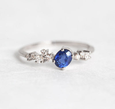 Ovaler blauer Saphir-Clusterring mit Diamanten