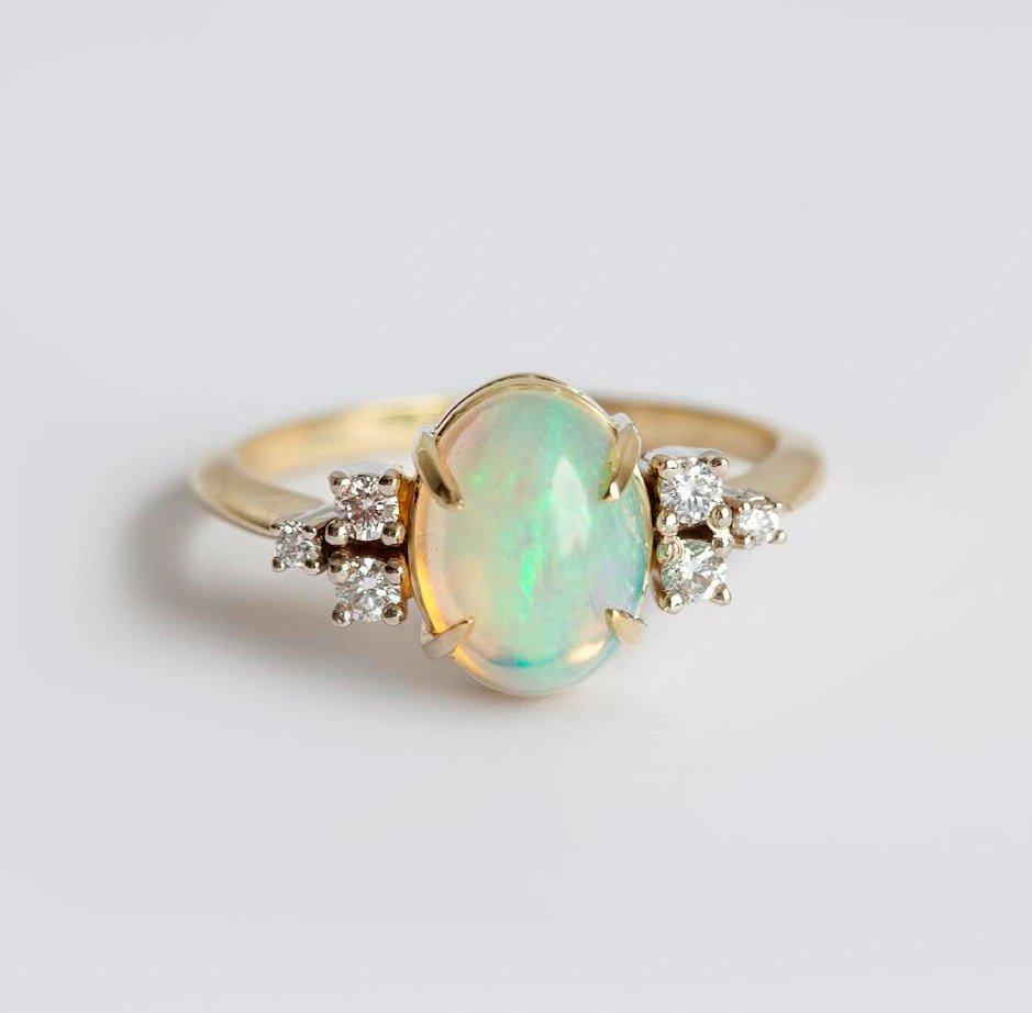 Ovaler Opal-Ehering mit Cabochon-Regenbogen und seitlichen weißen runden Diamanten